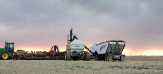 Modern Technology image – farmer checks seeding equipment